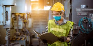 Female factory worker taking worksite safety seriously as she wears her hardhat, goggles and mask