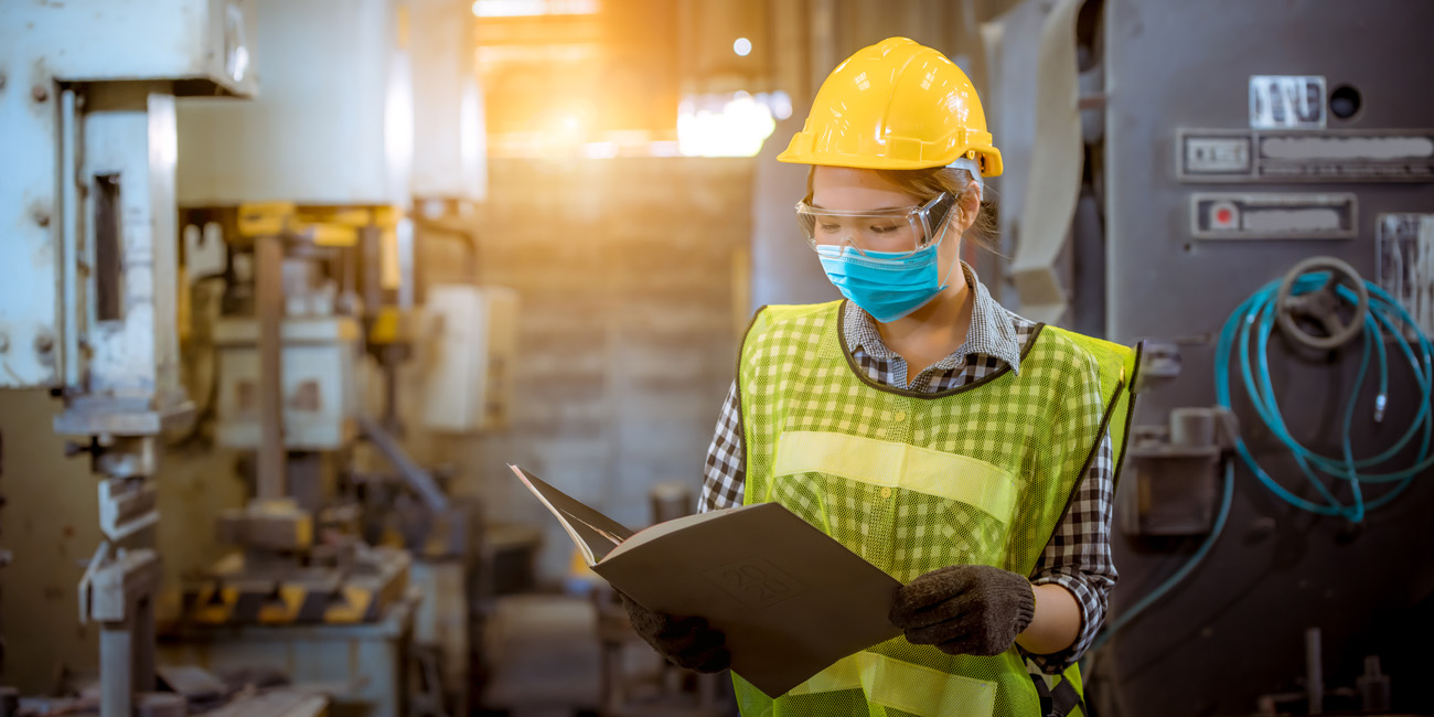 Female factory worker taking worksite safety seriously as she wears her hardhat, goggles and mask